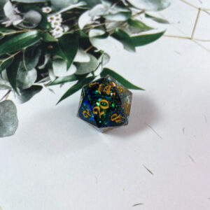 This D20 is filled with the most beautiful blue-green color shift glitter mixed with gold. This die reminds me of a dragon protecting its hoard. Incredibly sparkly, this double-pour is finished with gold inking.