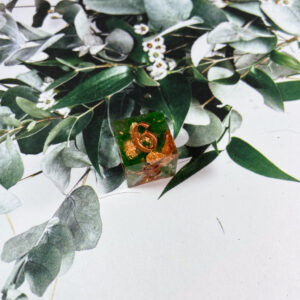 Ethereal in looks, this single D6 is made or rose gold leaf and flitter that swirl in a liquid core nestled in greenery and a flash of blue mylar. Finished with copper inking, a special beauty for your collection!